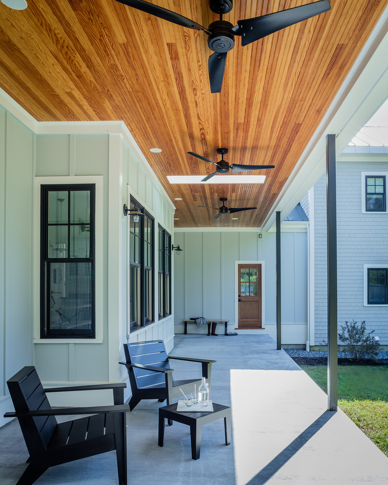 Geräumige, Überdachte Landhaus Veranda hinter dem Haus mit Betonplatten in Boston