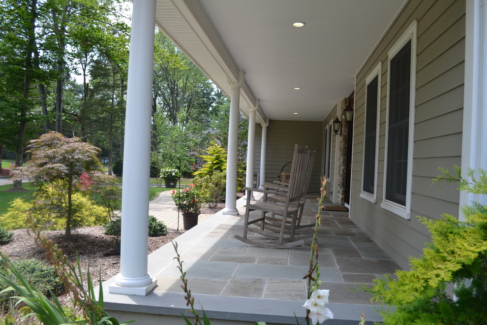 Imagen de terraza clásica de tamaño medio en patio delantero y anexo de casas con adoquines de hormigón