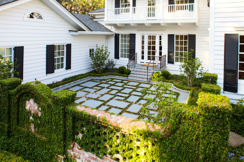 Imagen de terraza clásica grande en patio delantero con jardín de macetas y adoquines de piedra natural