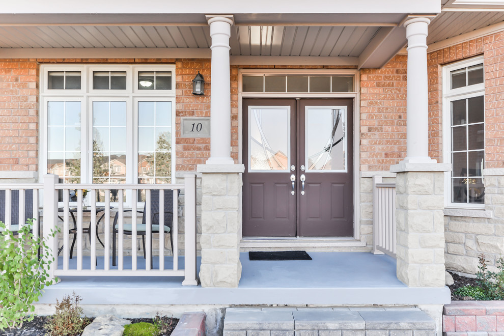 Cette photo montre un porche d'entrée de maison avant chic avec une dalle de béton et une extension de toiture.