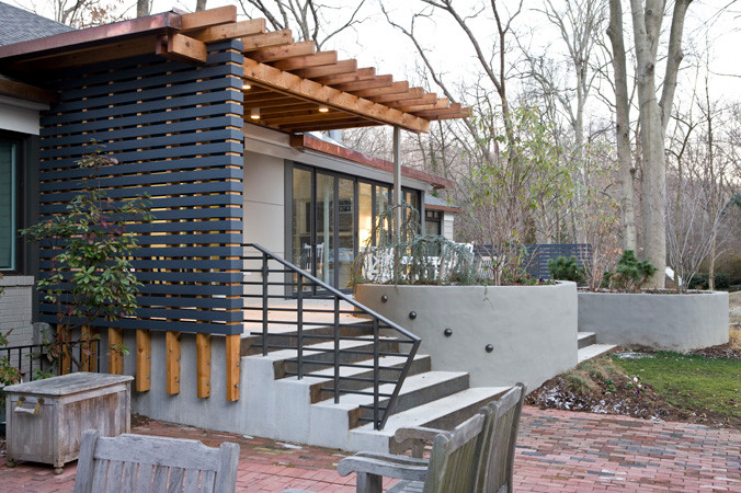 Esempio di un portico design di medie dimensioni e davanti casa con lastre di cemento e una pergola
