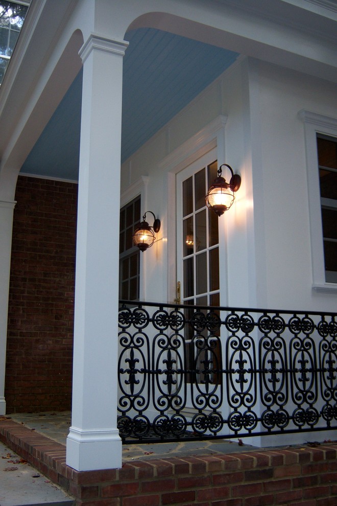 Inspiration for a mid-sized timeless brick side porch remodel in Baltimore with a roof extension