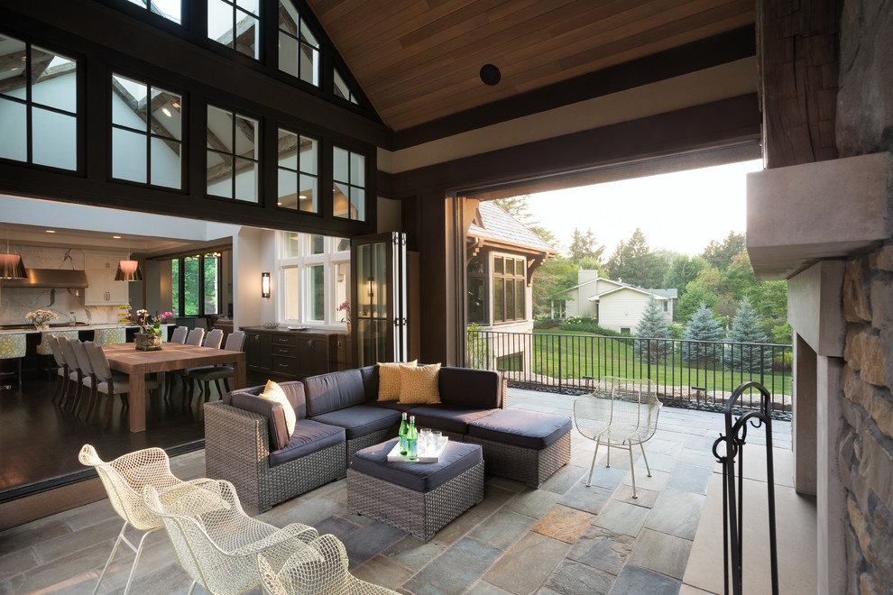 Transitional stone screened-in back porch idea in Minneapolis with a roof extension