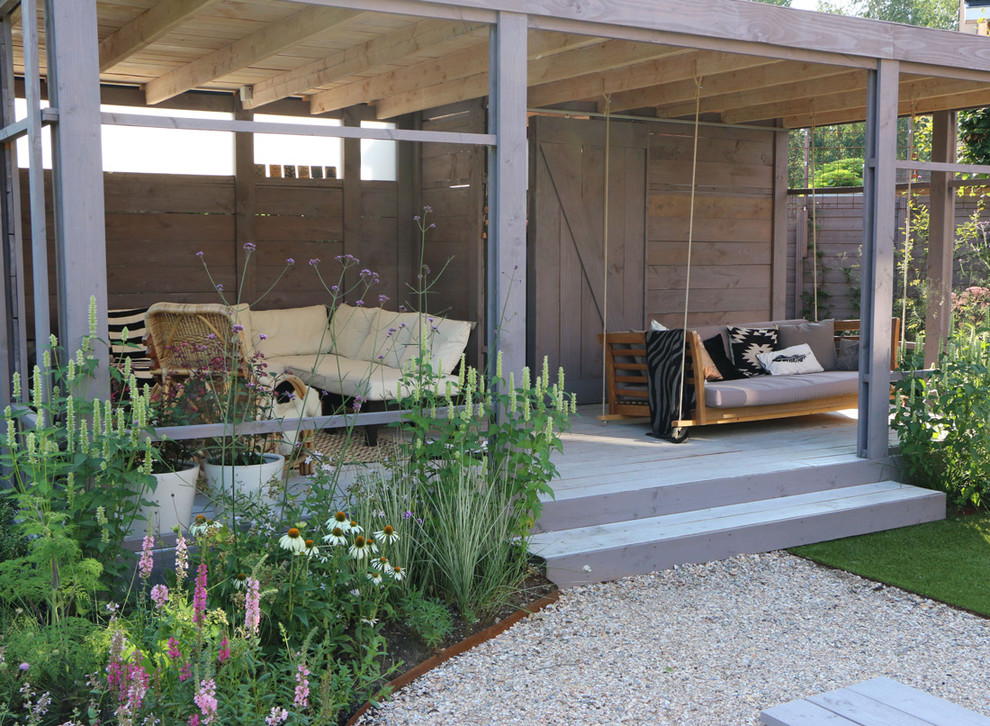 Cette photo montre un porche d'entrée de maison arrière montagne avec une terrasse en bois et une extension de toiture.