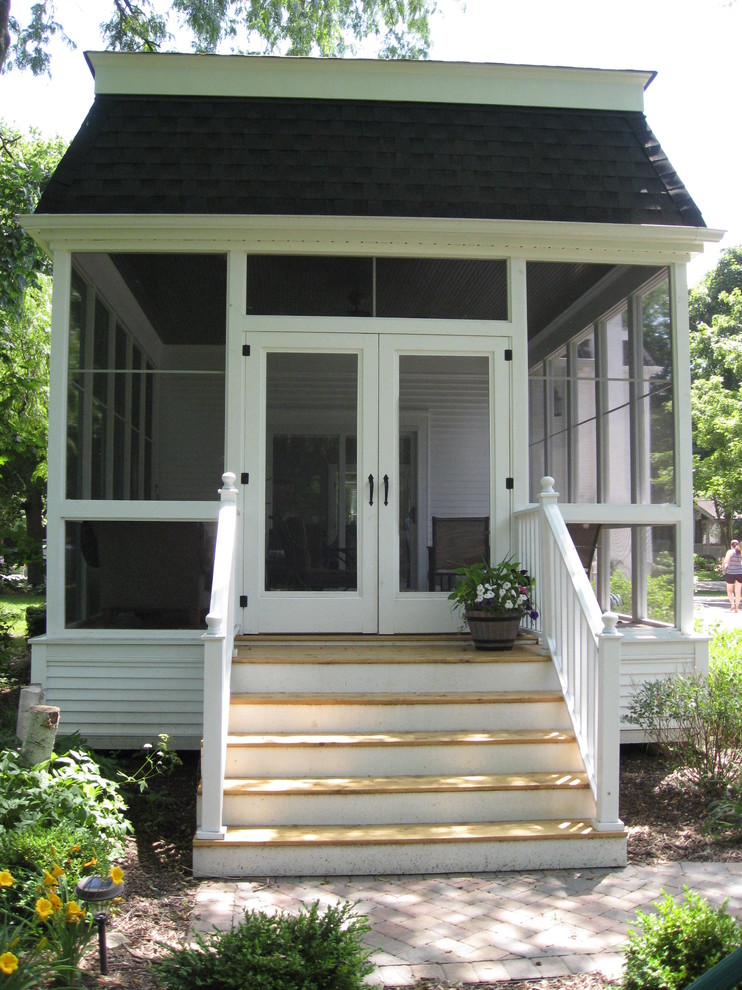 Foto på en amerikansk innätad veranda längs med huset, med takförlängning
