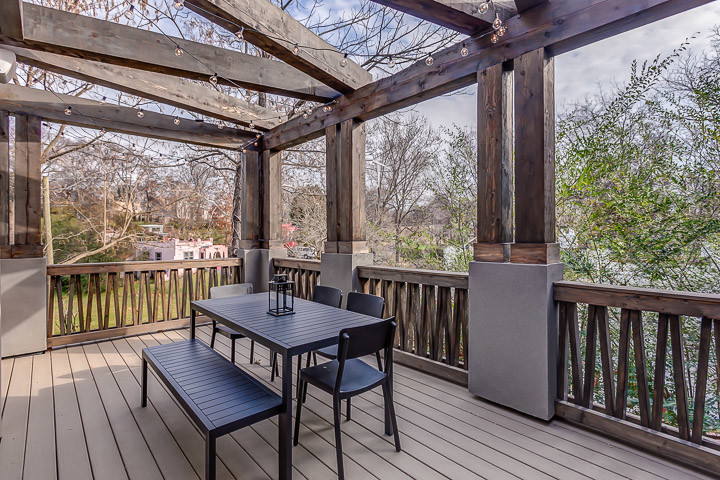 Réalisation d'un porche d'entrée de maison latéral minimaliste avec un foyer extérieur, une terrasse en bois et une pergola.