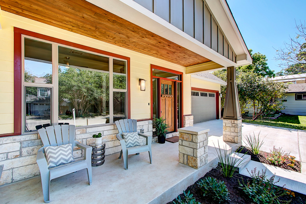 Aménagement d'un porche d'entrée de maison avant craftsman de taille moyenne avec une dalle de béton et une extension de toiture.