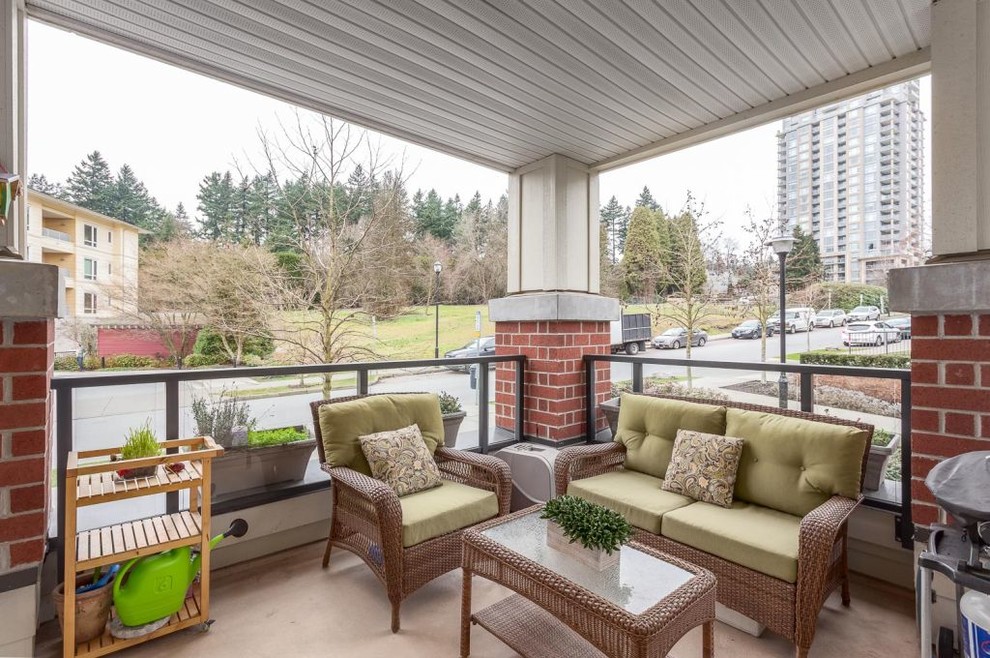 Photo of a medium sized traditional front veranda in Vancouver with concrete paving and a roof extension.