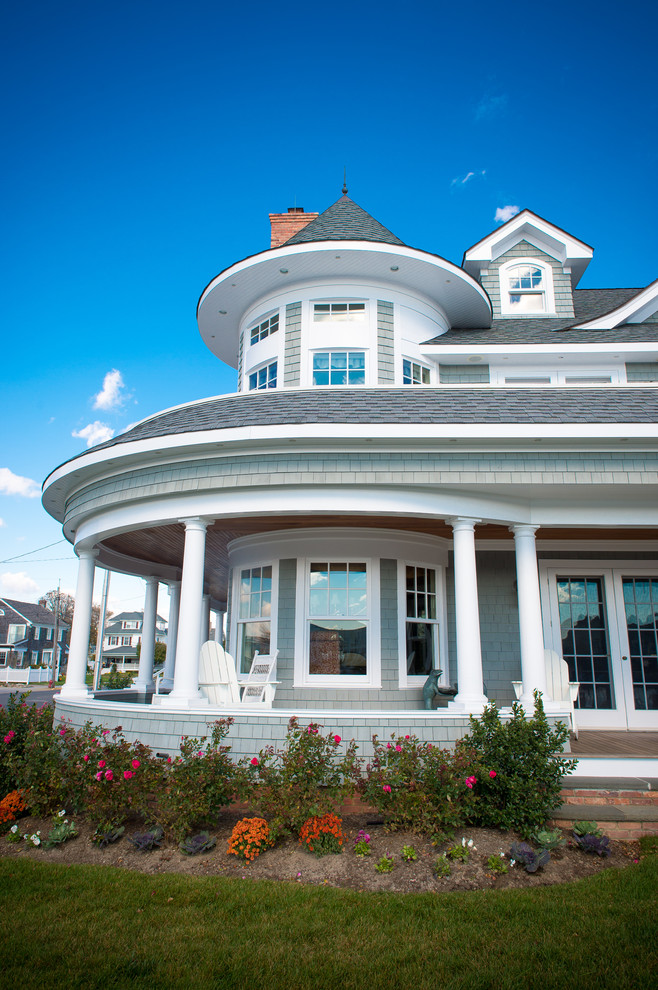 This is an example of a large coastal side porch design in New York with a roof extension and decking.
