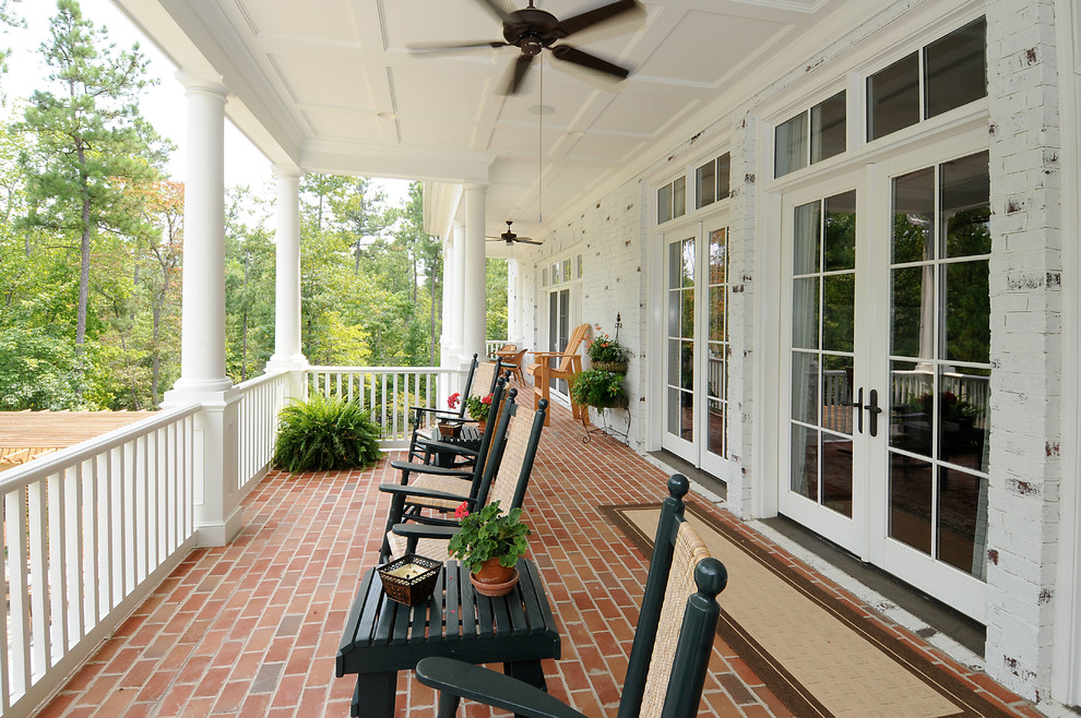 Design ideas for a traditional veranda in Raleigh with brick paving and a roof extension.