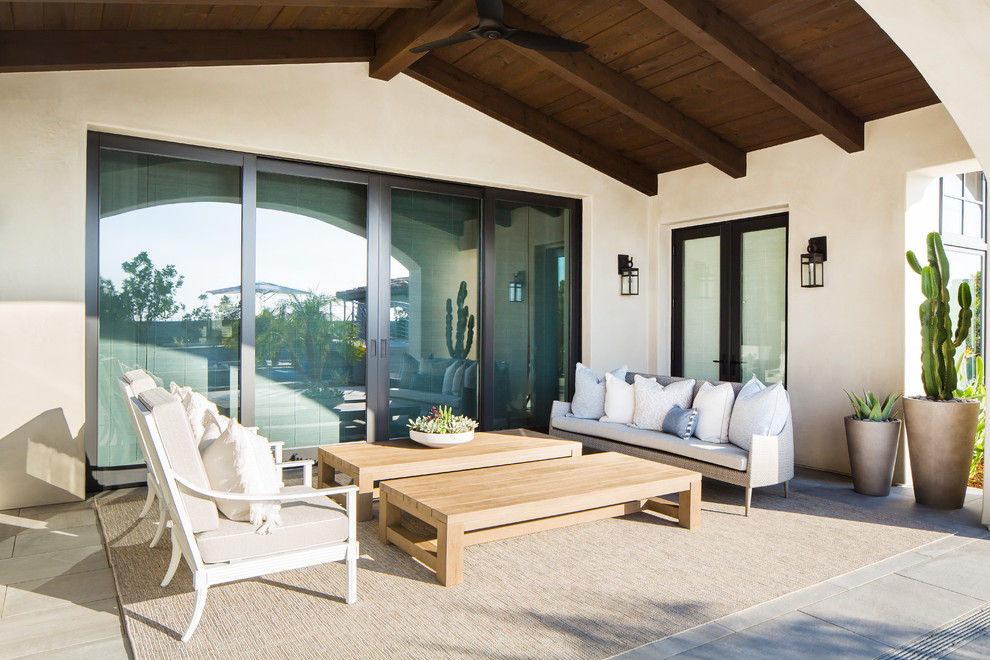 This is an example of an expansive mediterranean back veranda in San Diego with a roof extension.