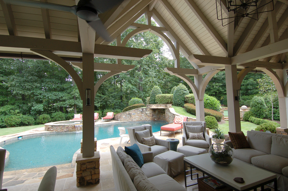Diseño de terraza clásica renovada grande en patio trasero con adoquines de piedra natural y fuente