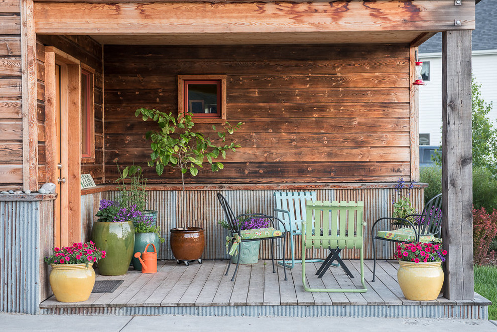 Idéer för en liten rustik veranda framför huset, med utekrukor, trädäck och takförlängning