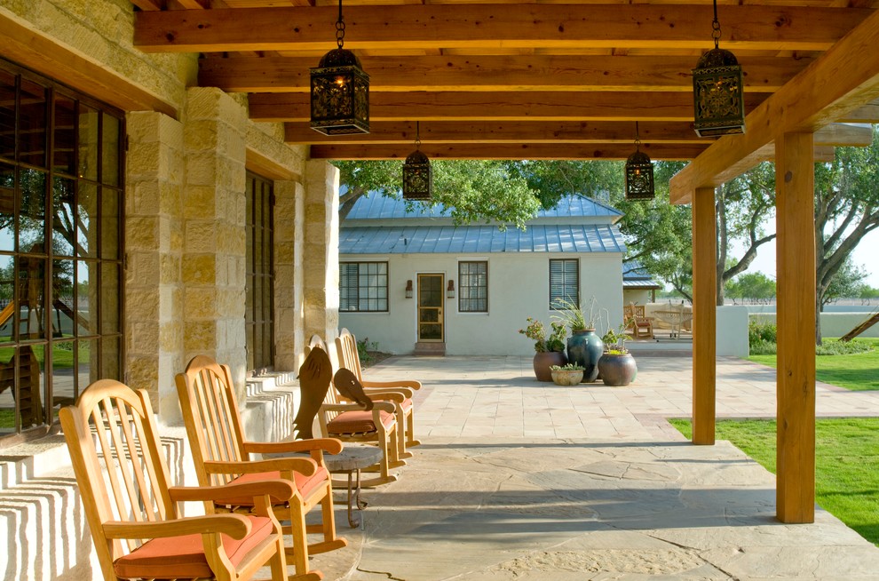 Diseño de terraza de estilo americano en anexo de casas con adoquines de piedra natural