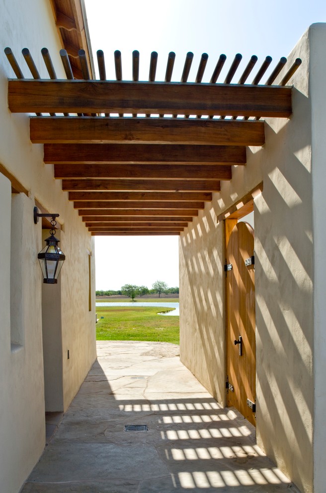 This is an example of a southwestern porch design in Houston.
