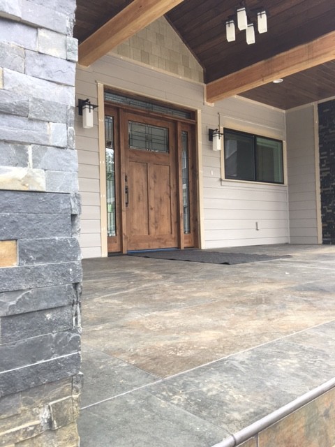 Foto di un portico design di medie dimensioni e davanti casa con lastre di cemento e un tetto a sbalzo