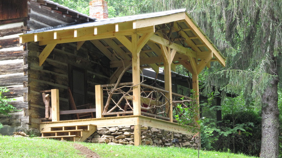 This is an example of a rustic porch design in Other with decking and a roof extension.