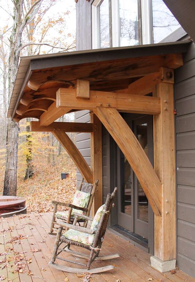 Exempel på en mellanstor rustik veranda på baksidan av huset, med trädäck och takförlängning