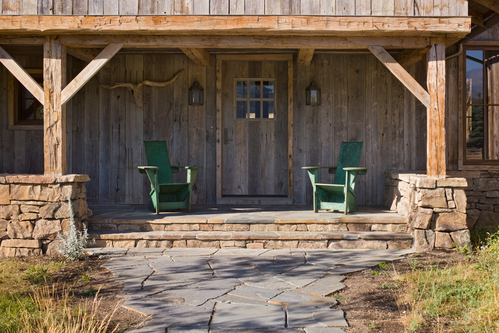 Idée de décoration pour un porche d'entrée de maison avant chalet avec une extension de toiture.