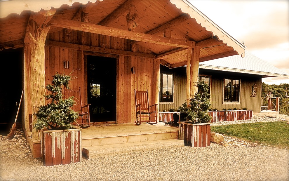 Exemple d'un petit porche avec des plantes en pot avant montagne avec une terrasse en bois et une extension de toiture.