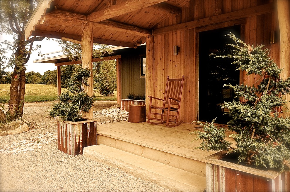 Ispirazione per un piccolo portico stile rurale davanti casa con un giardino in vaso, pedane e un tetto a sbalzo