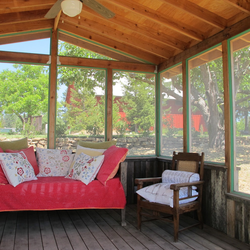 Exemple d'un porche d'entrée de maison arrière montagne de taille moyenne avec une moustiquaire, une terrasse en bois et une extension de toiture.