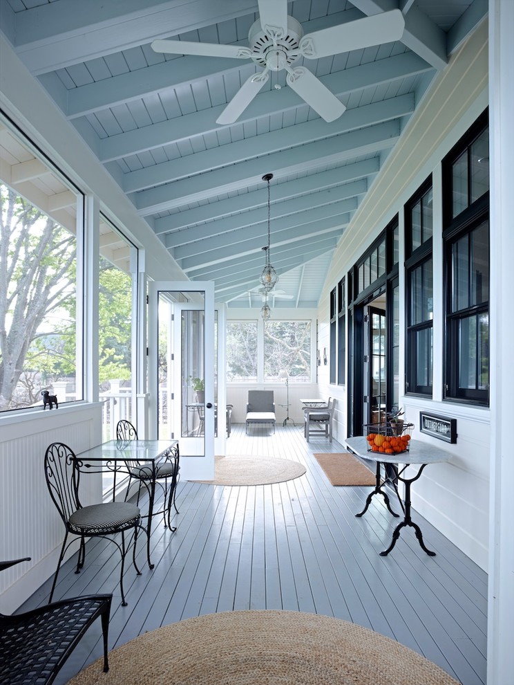 Aménagement d'un grand porche d'entrée de maison arrière classique avec une moustiquaire, une terrasse en bois et une extension de toiture.