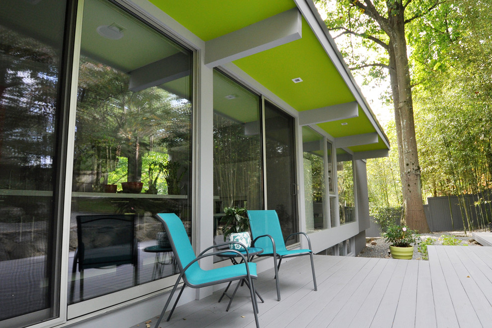 Inspiration for a large modern back veranda in New York with decking and a roof extension.