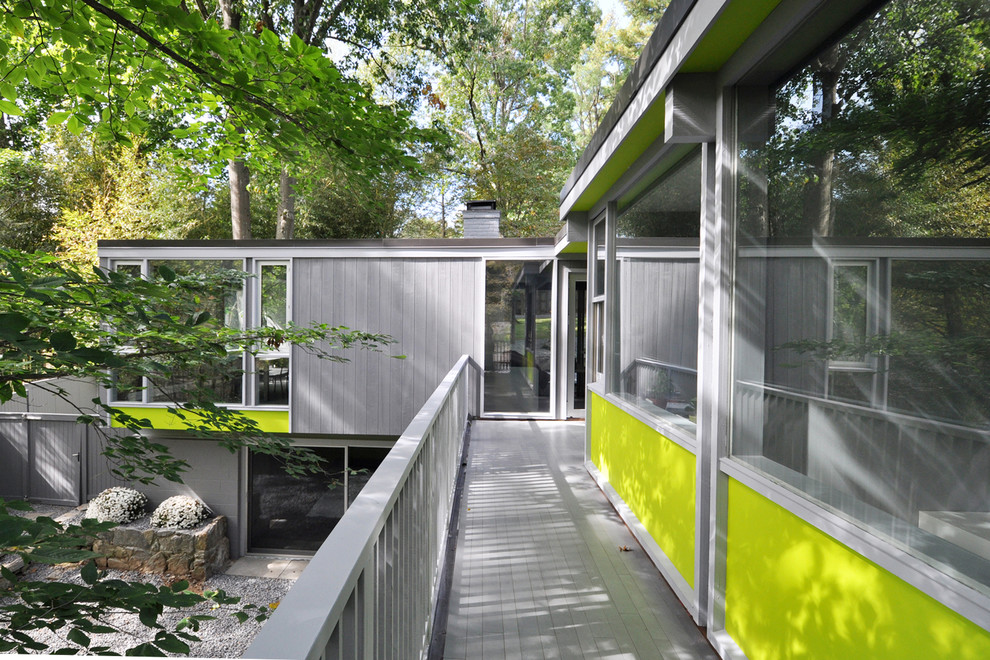 Ejemplo de terraza minimalista grande en patio trasero y anexo de casas con entablado