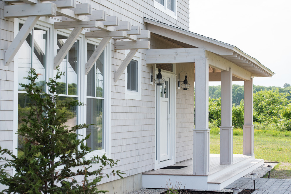 Transitional front porch idea in Manchester with an awning
