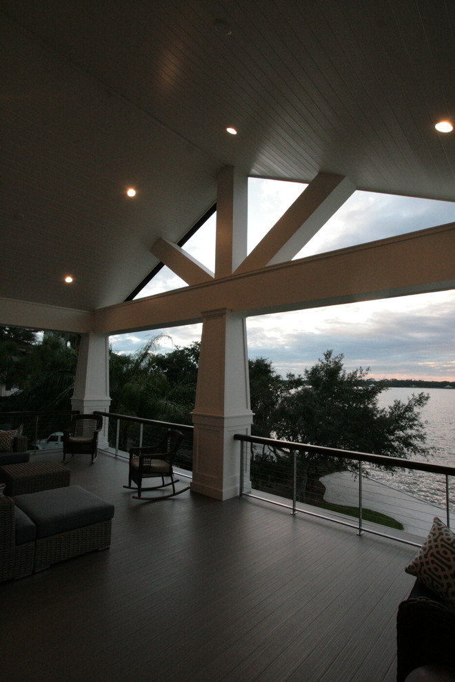 This is an example of a large coastal tile back porch design in Miami with a roof extension.