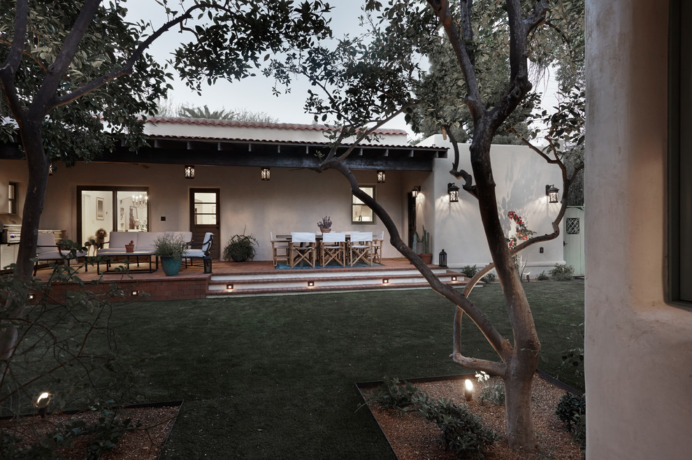 Cette image montre un grand porche d'entrée de maison arrière sud-ouest américain avec des pavés en brique et une extension de toiture.