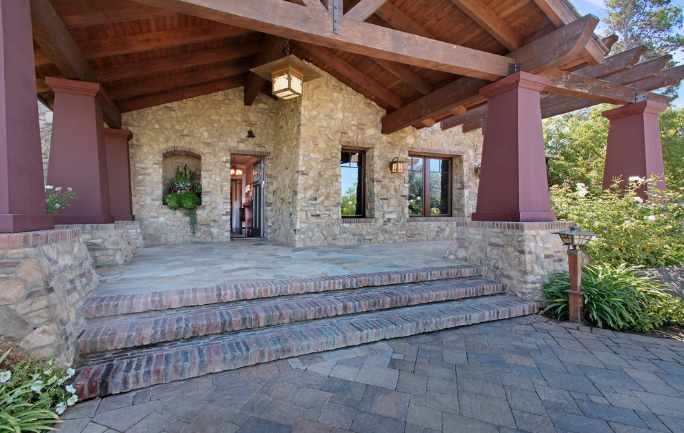 Esempio di un ampio portico stile americano davanti casa con pavimentazioni in pietra naturale e un tetto a sbalzo