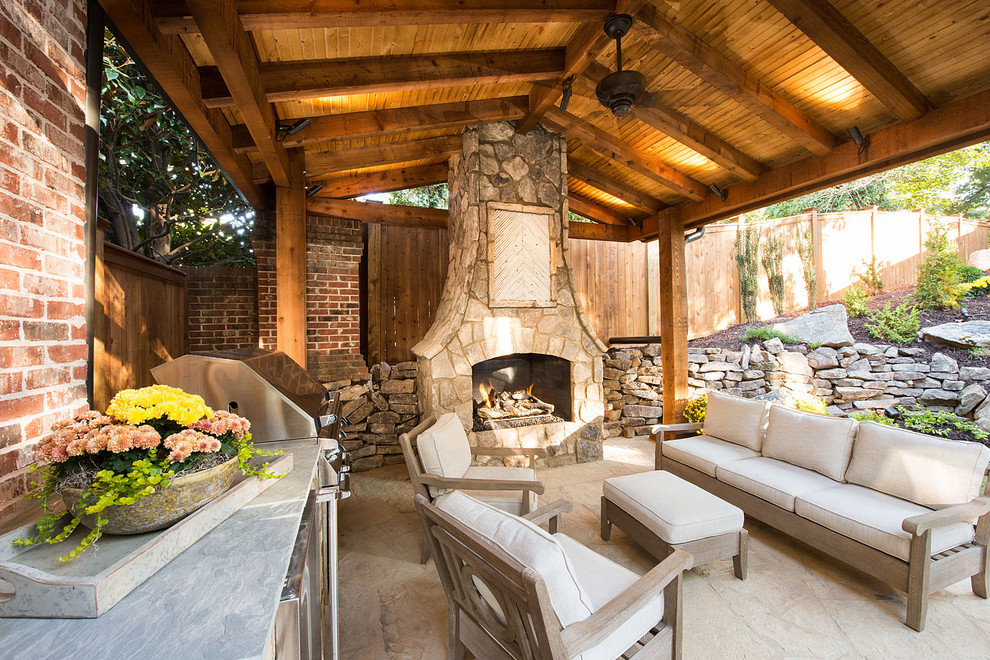 Modelo de terraza de estilo americano grande en patio trasero con adoquines de piedra natural, cocina exterior y pérgola