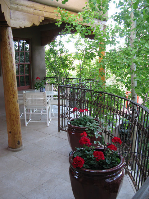 Foto de terraza de estilo americano en patio trasero y anexo de casas con suelo de baldosas y jardín de macetas