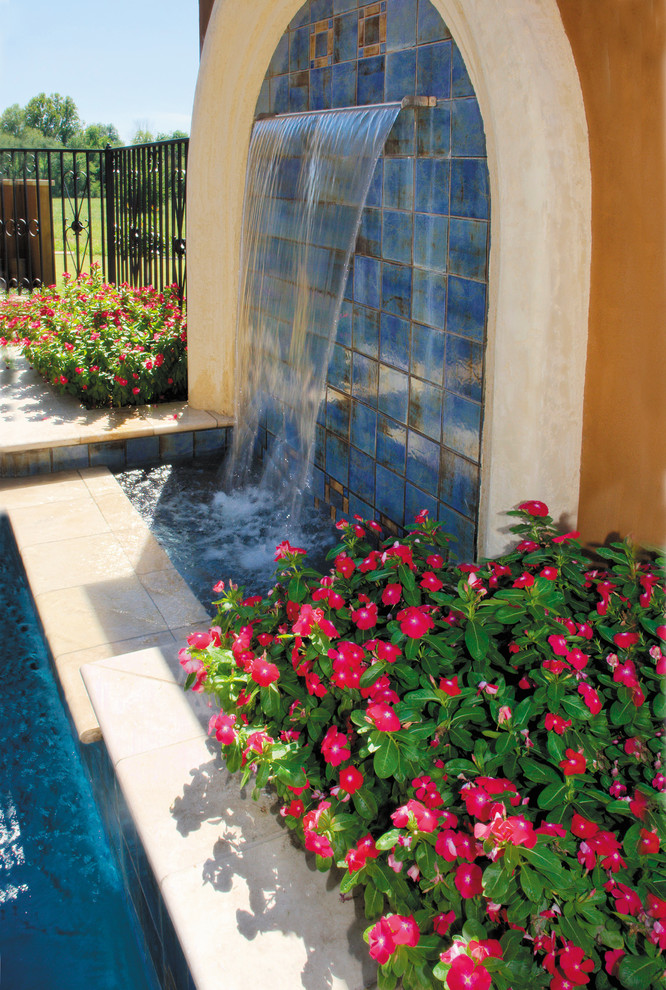 Idées déco pour un grand porche d'entrée de maison méditerranéen avec un point d'eau et des pavés en pierre naturelle.