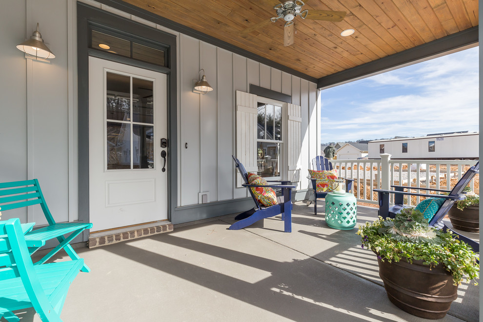 Exemple d'un porche d'entrée de maison avant chic de taille moyenne avec une dalle de béton et une extension de toiture.