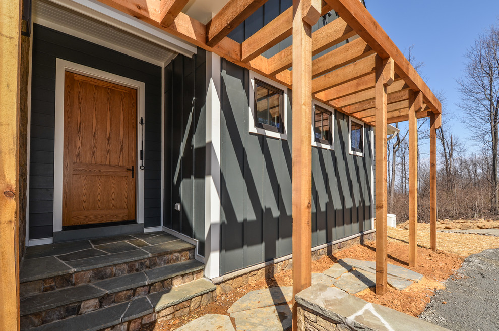 Exemple d'un grand porche d'entrée de maison avant nature avec des pavés en pierre naturelle et une pergola.