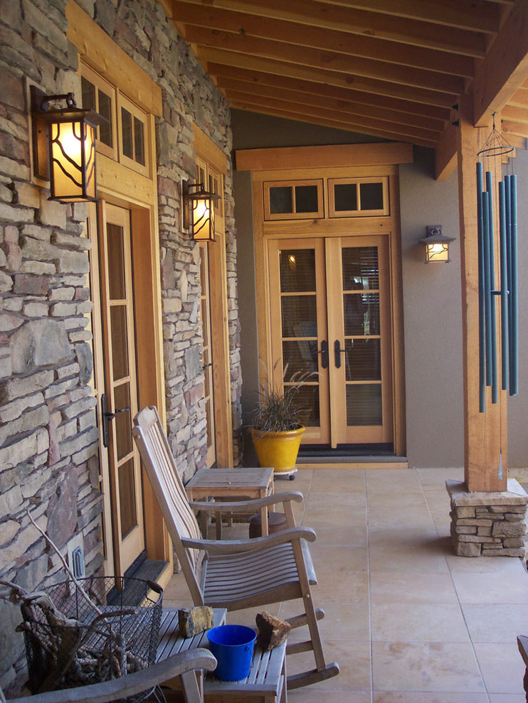 Idée de décoration pour un porche d'entrée de maison arrière craftsman de taille moyenne avec du carrelage et une extension de toiture.