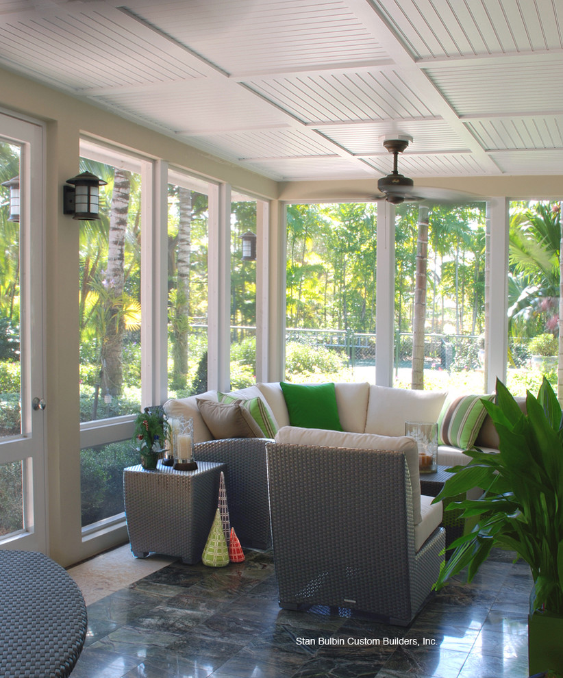 Inspiration for a large contemporary tile screened-in back porch remodel in Miami with a roof extension