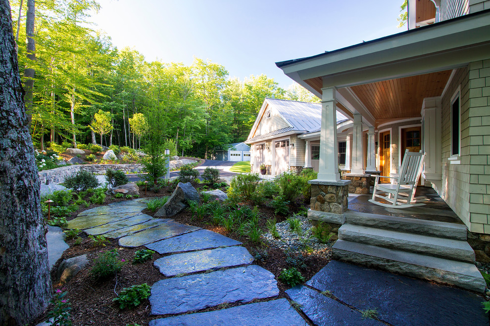 Elegant stone front porch photo in Burlington with a roof extension