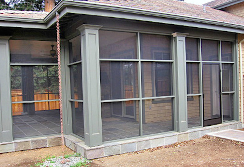 Exemple d'un porche d'entrée de maison arrière chic de taille moyenne avec une moustiquaire, des pavés en pierre naturelle et une extension de toiture.