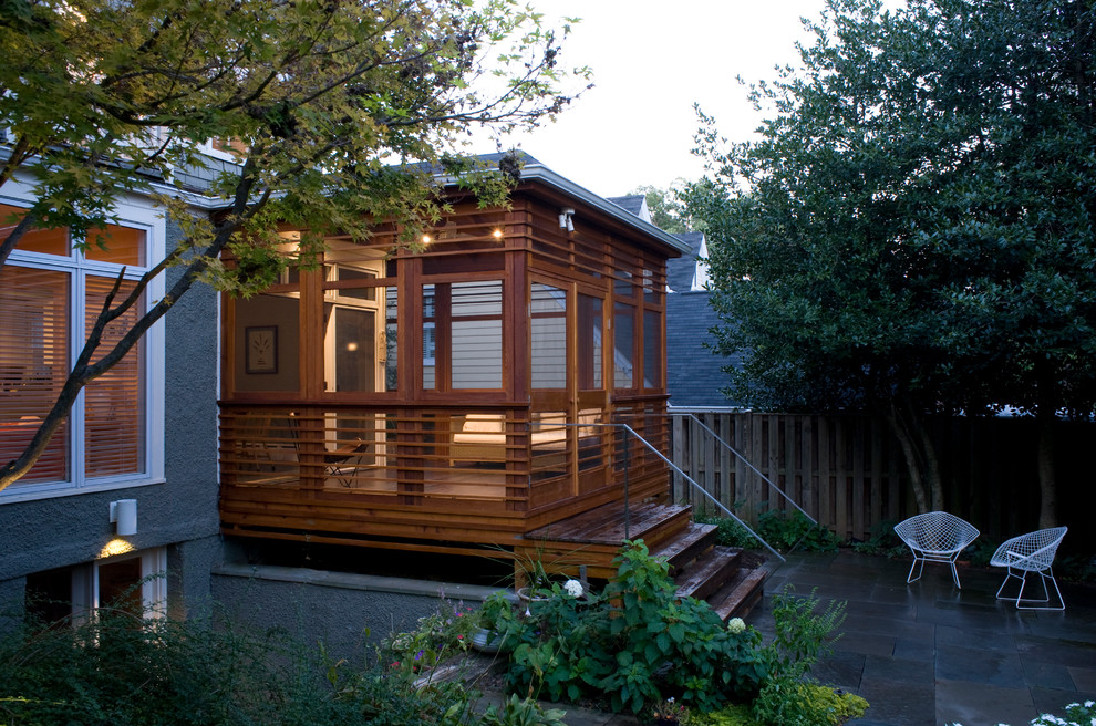 Idée de décoration pour un porche d'entrée de maison design avec une extension de toiture et une moustiquaire.