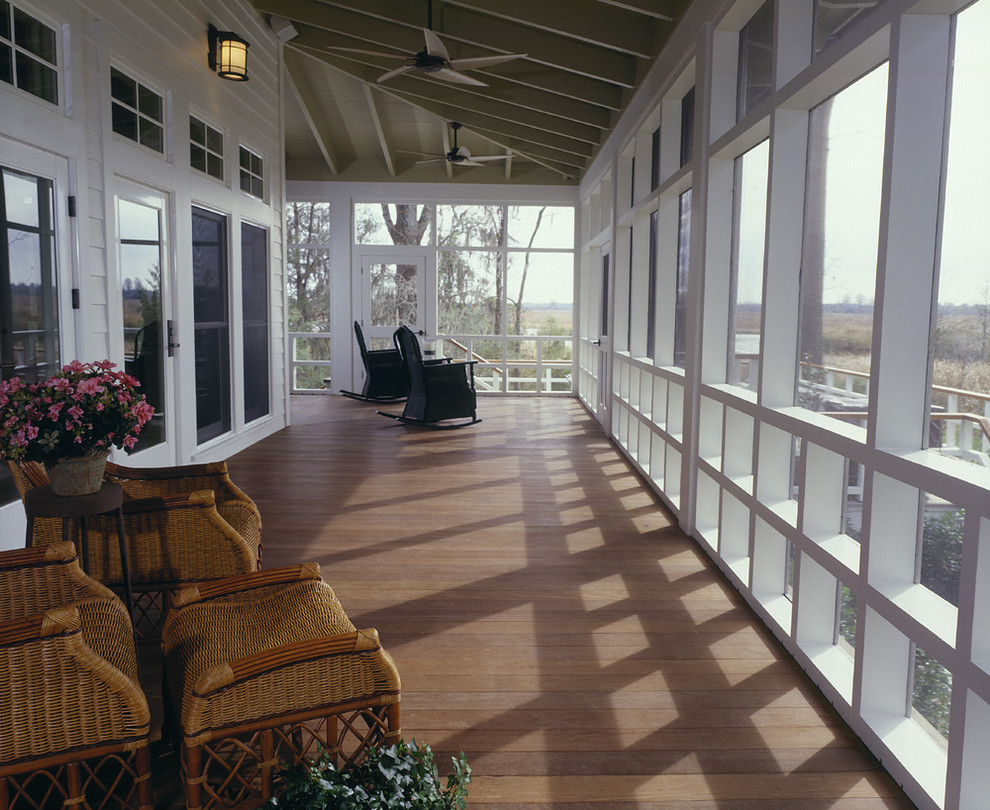 This is an example of a large cottage screened-in back porch design in Atlanta with decking and a roof extension.