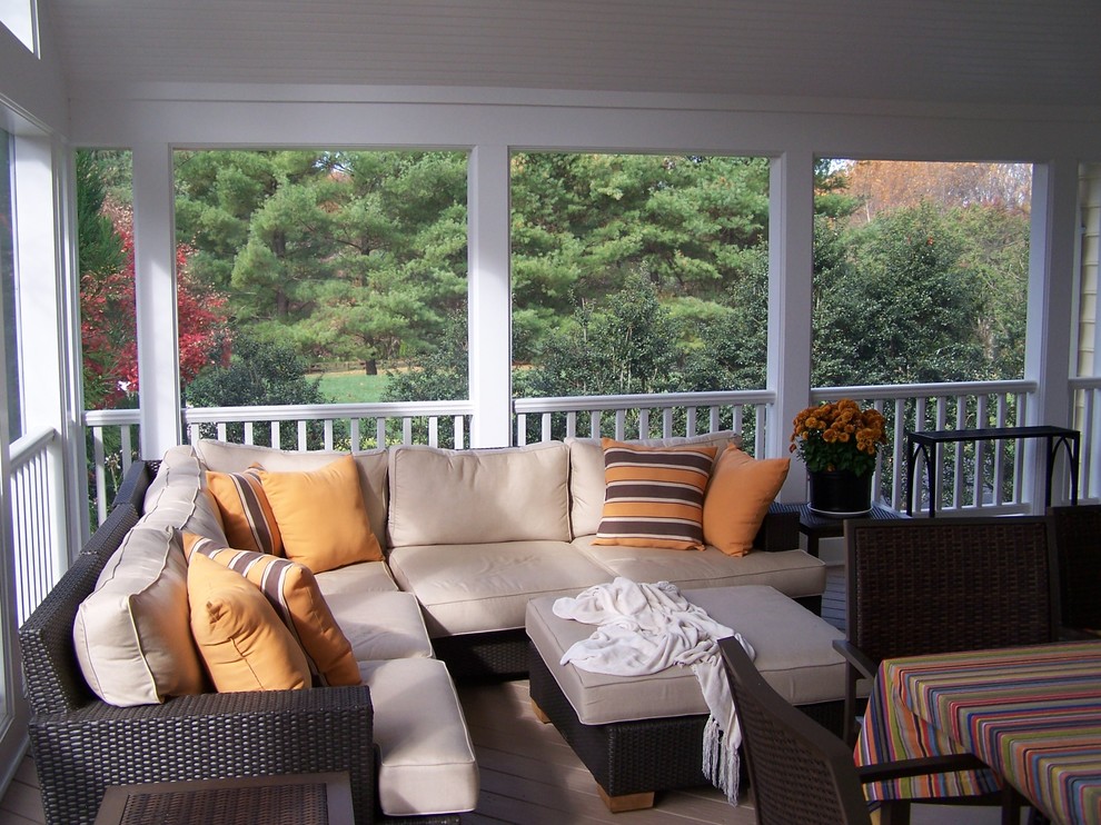 Cette image montre un porche d'entrée de maison arrière traditionnel avec une moustiquaire, une terrasse en bois et une extension de toiture.