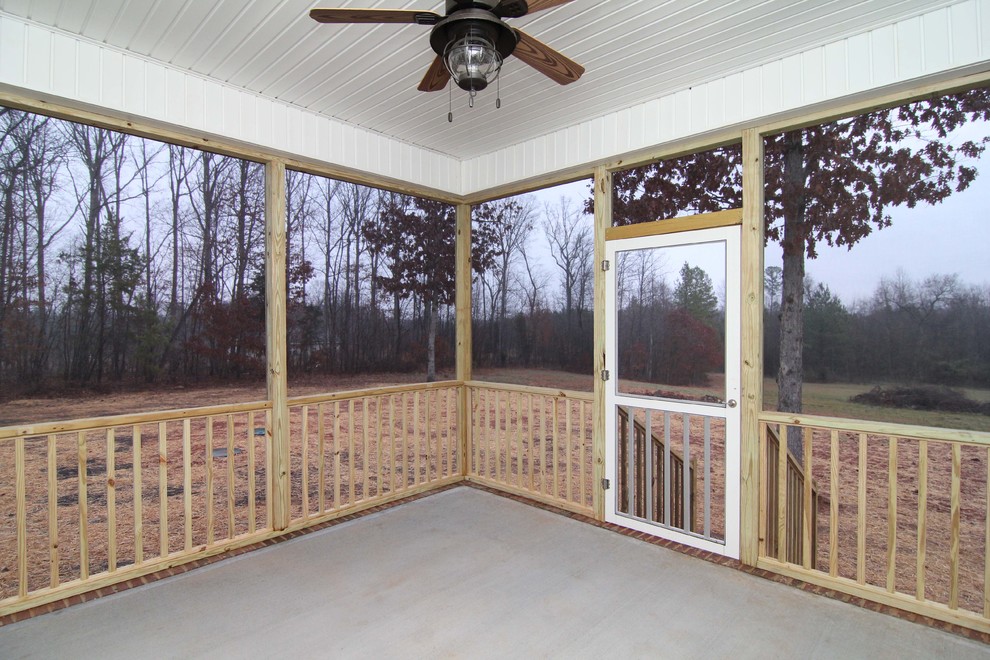 Idées déco pour un petit porche d'entrée de maison arrière classique avec une dalle de béton et une extension de toiture.