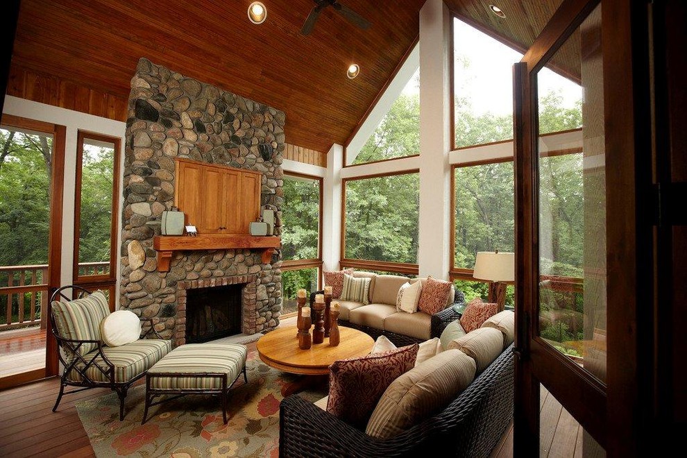 Idée de décoration pour un porche d'entrée de maison tradition avec un foyer extérieur, une terrasse en bois, une extension de toiture et tous types de couvertures.