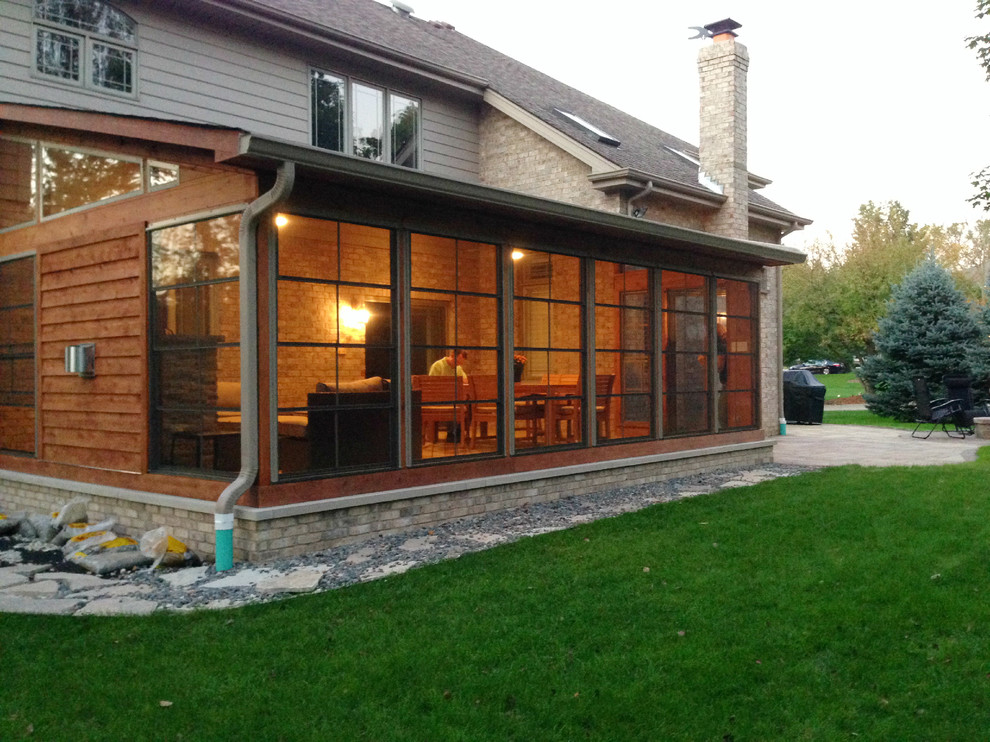 Rustik inredning av en mellanstor innätad veranda på baksidan av huset, med takförlängning och trädäck