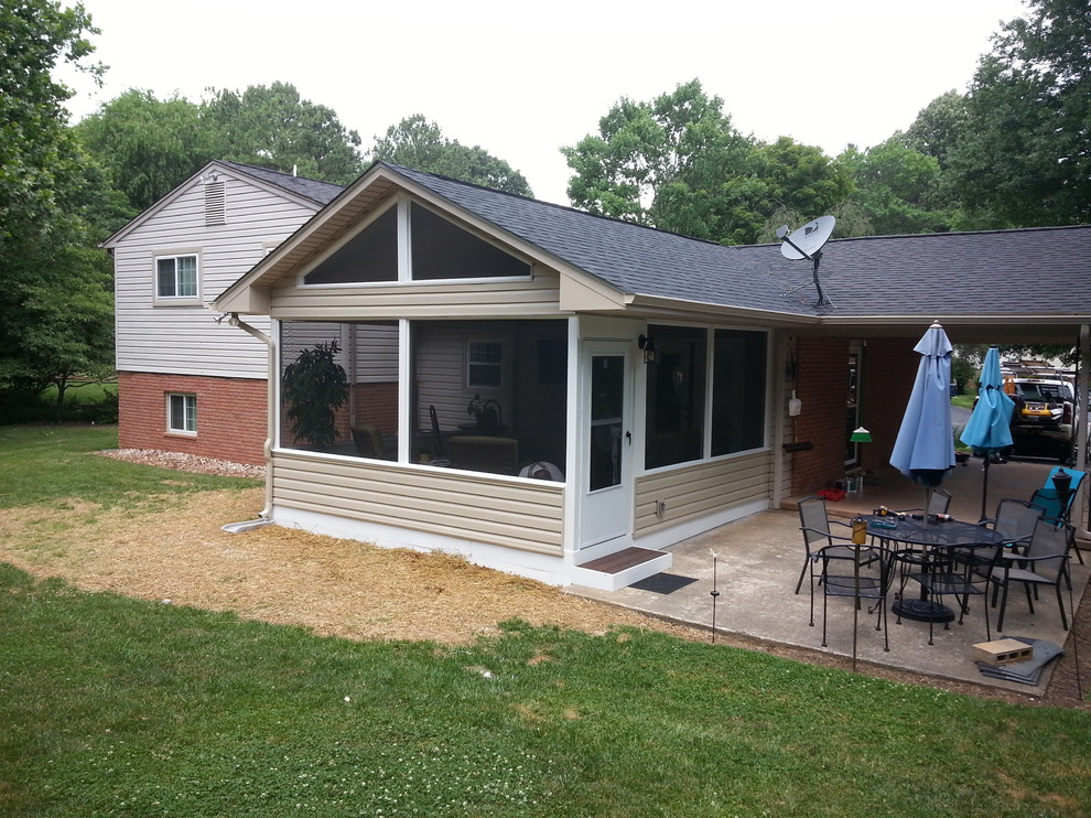 Inspiration for a mid-sized timeless stamped concrete screened-in back porch remodel in Other with a roof extension