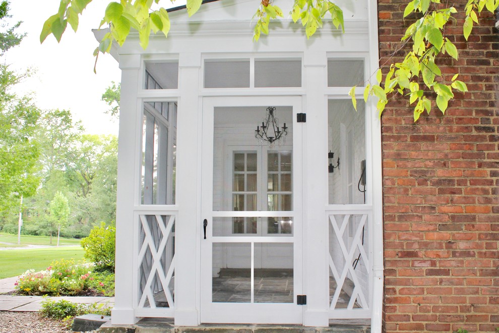 Imagen de porche cerrado clásico de tamaño medio en patio delantero y anexo de casas con adoquines de piedra natural